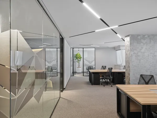 Executive suite with team workstations and glass-walled private offices