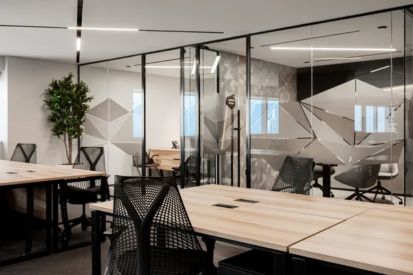 Executive suite workstations beside glass-walled offices