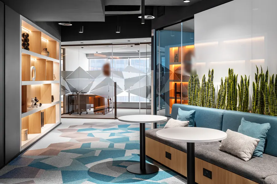 Modern lounge with sofa seating beside glass-fronted serviced offices